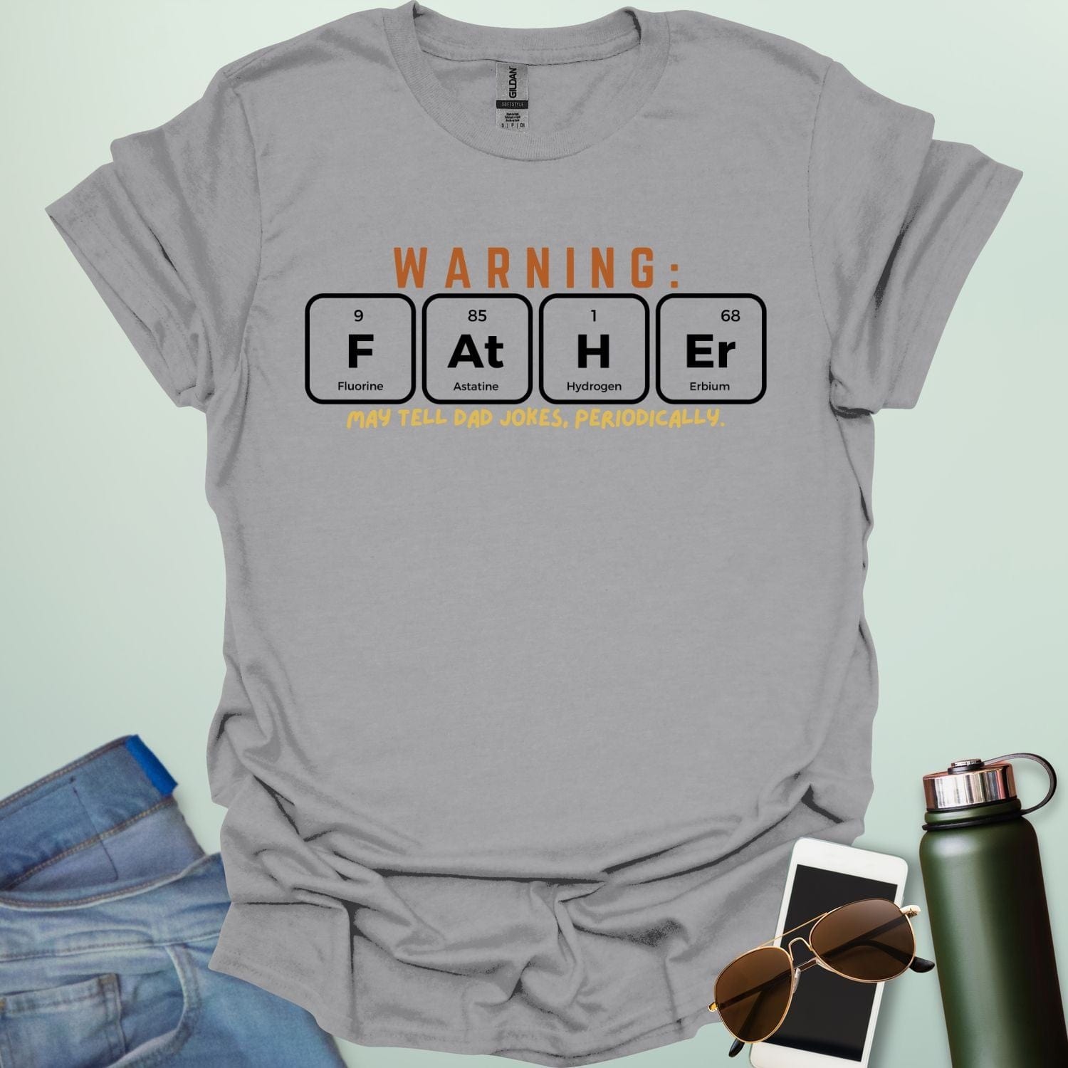 A funny periodic table t-shirt for fathers, using the elements Fluorine, Astatine, Hydrogen, and Erbium to spell 'FAtHEr'. The design says 'WARNING: FATHER MAY TELL DAD JOKES, PERIODICALLY.'