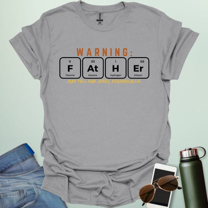 A funny periodic table t-shirt for fathers, using the elements Fluorine, Astatine, Hydrogen, and Erbium to spell 'FAtHEr'. The design says 'WARNING: FATHER MAY TELL DAD JOKES, PERIODICALLY.'