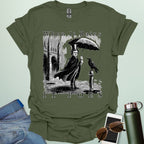 A literary pun t-shirt with a vintage illustration of Edgar Allan Poe holding an umbrella in the rain, next to a raven. The text reads 'When It Rains It Poes.'
