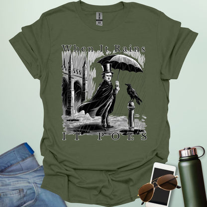 A literary pun t-shirt with a vintage illustration of Edgar Allan Poe holding an umbrella in the rain, next to a raven. The text reads 'When It Rains It Poes.'