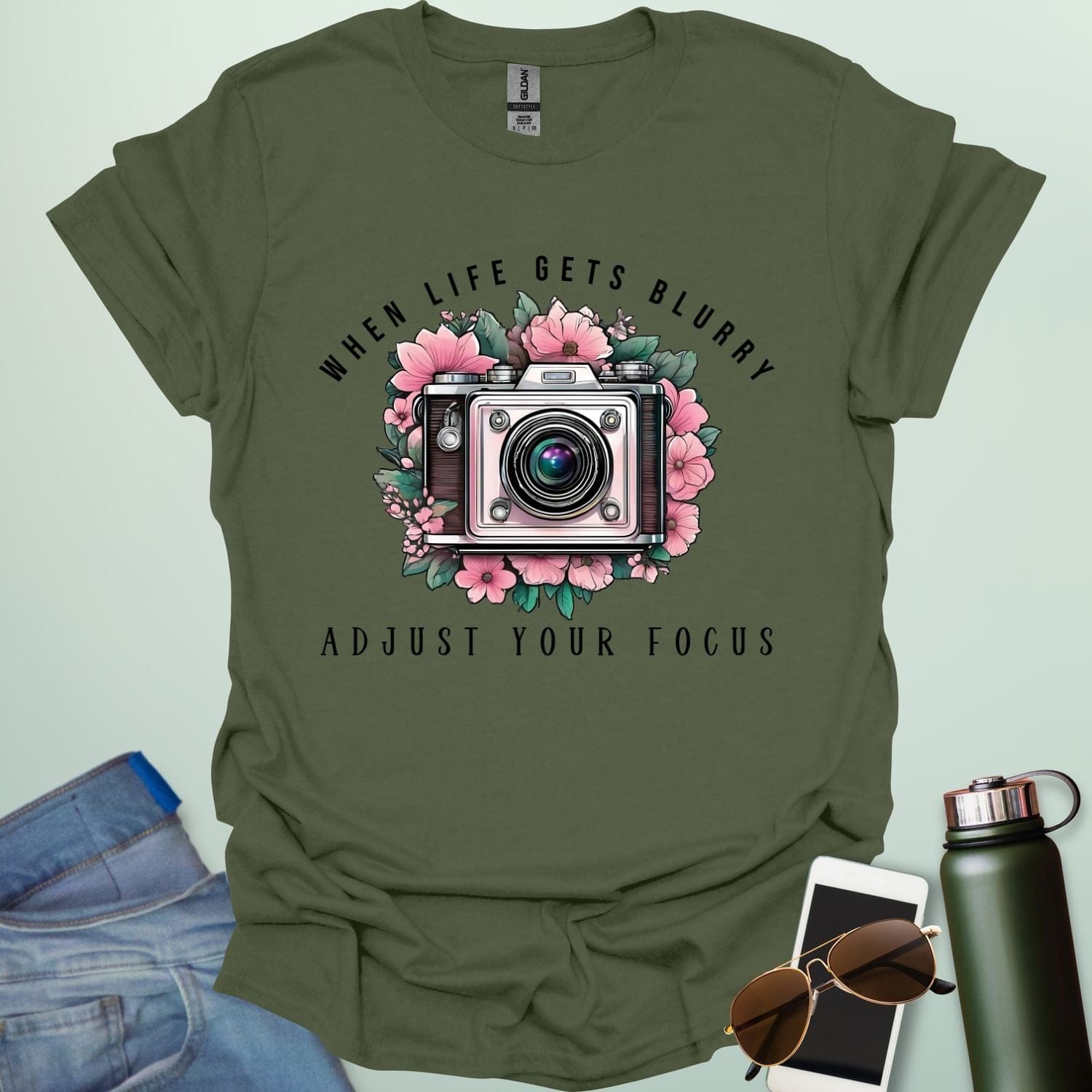 Vintage camera surrounded by flowers with the quote “When Life Gets Blurry, Adjust Your Focus.”
