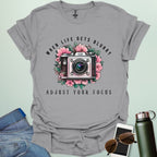 Vintage camera surrounded by flowers with the quote “When Life Gets Blurry, Adjust Your Focus.”