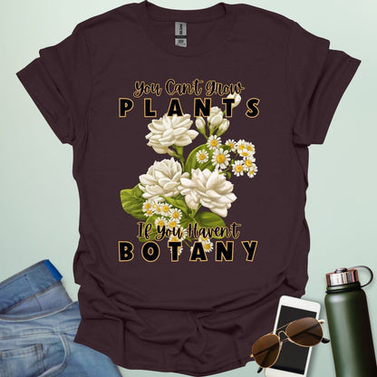A charming t-shirt with a floral design and the text 'You Can't Grow Plants If You Haven't Botany,' a witty pun for botanists and gardeners.