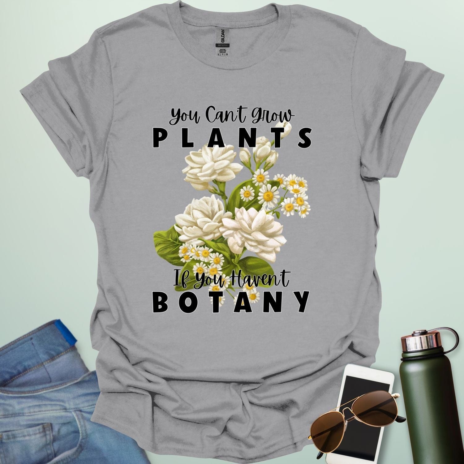 A charming t-shirt with a floral design and the text 'You Can't Grow Plants If You Haven't Botany,' a witty pun for botanists and gardeners.