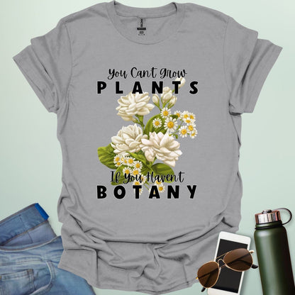 A charming t-shirt with a floral design and the text 'You Can't Grow Plants If You Haven't Botany,' a witty pun for botanists and gardeners.
