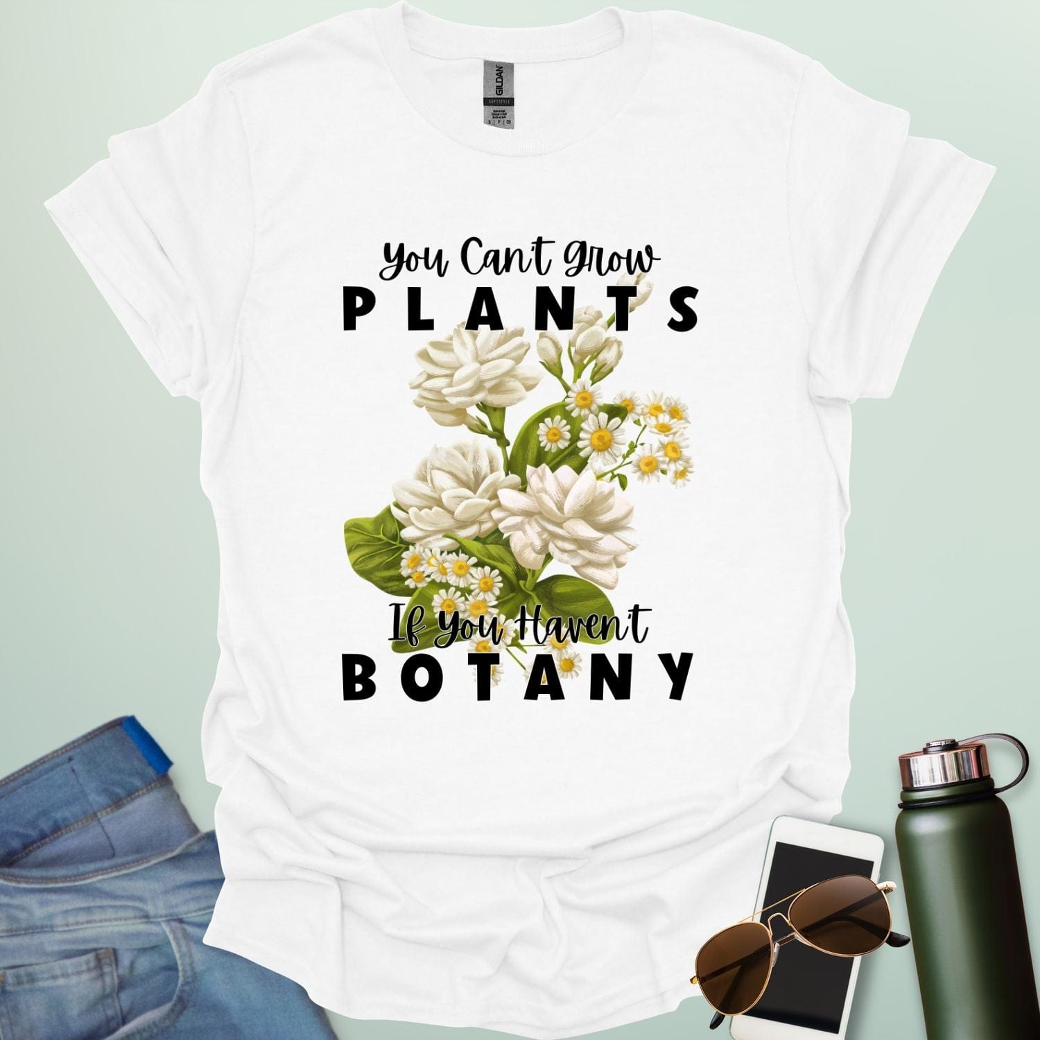 A charming t-shirt with a floral design and the text 'You Can't Grow Plants If You Haven't Botany,' a witty pun for botanists and gardeners.