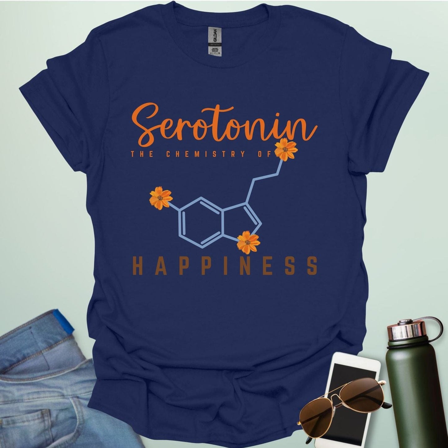 The word 'Serotonin' in cursive orange font above the text 'THE CHEMISTRY OF' in smaller orange font, above the chemical structure of serotonin in light blue with three orange flowers incorporated into the bonds. Below the chemical structure is the word 'HAPPINESS' in bold orange font.