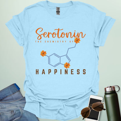 The word 'Serotonin' in cursive orange font above the text 'THE CHEMISTRY OF' in smaller orange font, above the chemical structure of serotonin in light blue with three orange flowers incorporated into the bonds. Below the chemical structure is the word 'HAPPINESS' in bold orange font.