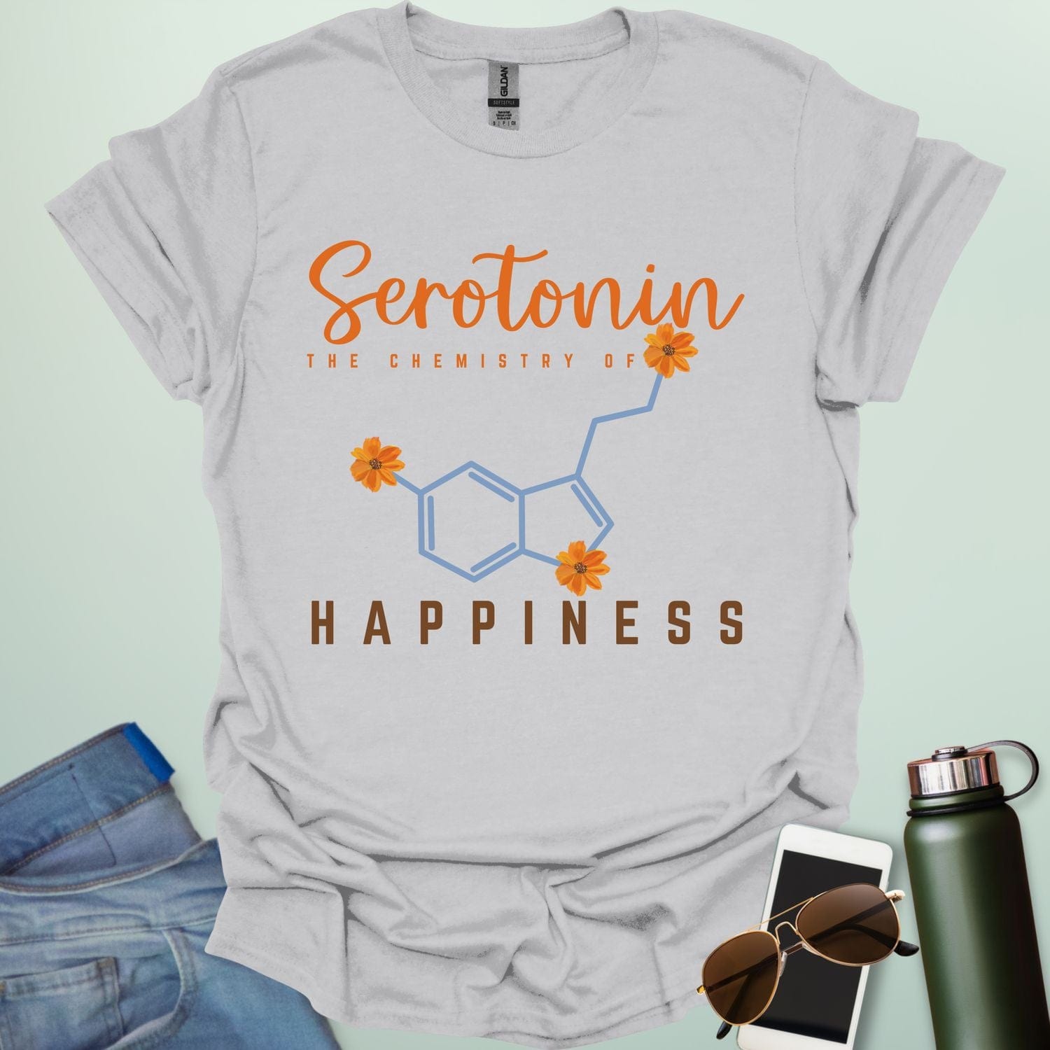 The word 'Serotonin' in cursive orange font above the text 'THE CHEMISTRY OF' in smaller orange font, above the chemical structure of serotonin in light blue with three orange flowers incorporated into the bonds. Below the chemical structure is the word 'HAPPINESS' in bold orange font.