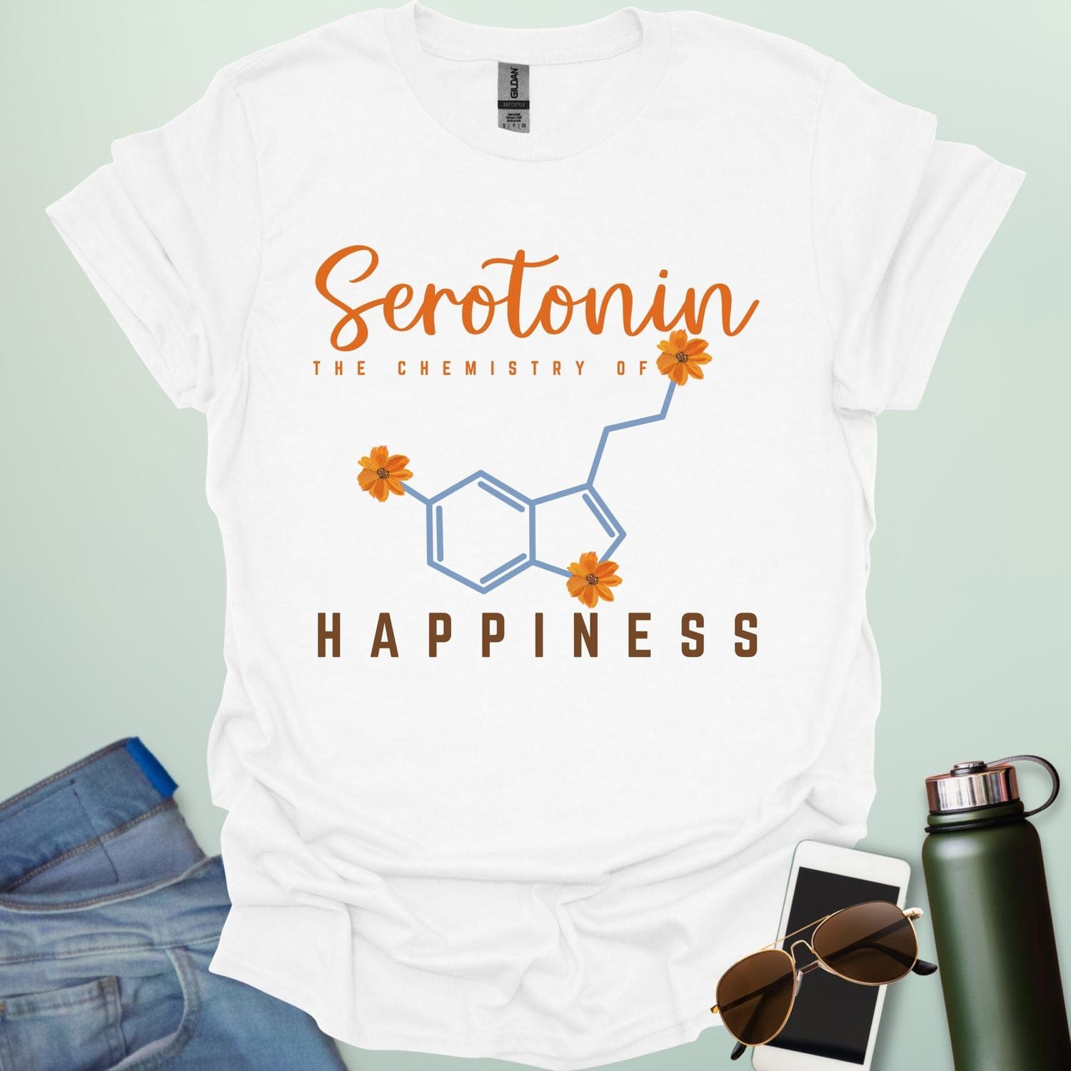 The word 'Serotonin' in cursive orange font above the text 'THE CHEMISTRY OF' in smaller orange font, above the chemical structure of serotonin in light blue with three orange flowers incorporated into the bonds. Below the chemical structure is the word 'HAPPINESS' in bold orange font.