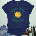 A cheerful graphic design featuring a smiling yellow proton character with orbiting electrons and the text "BE LIKE A PROTON STAY POSITIVE."
