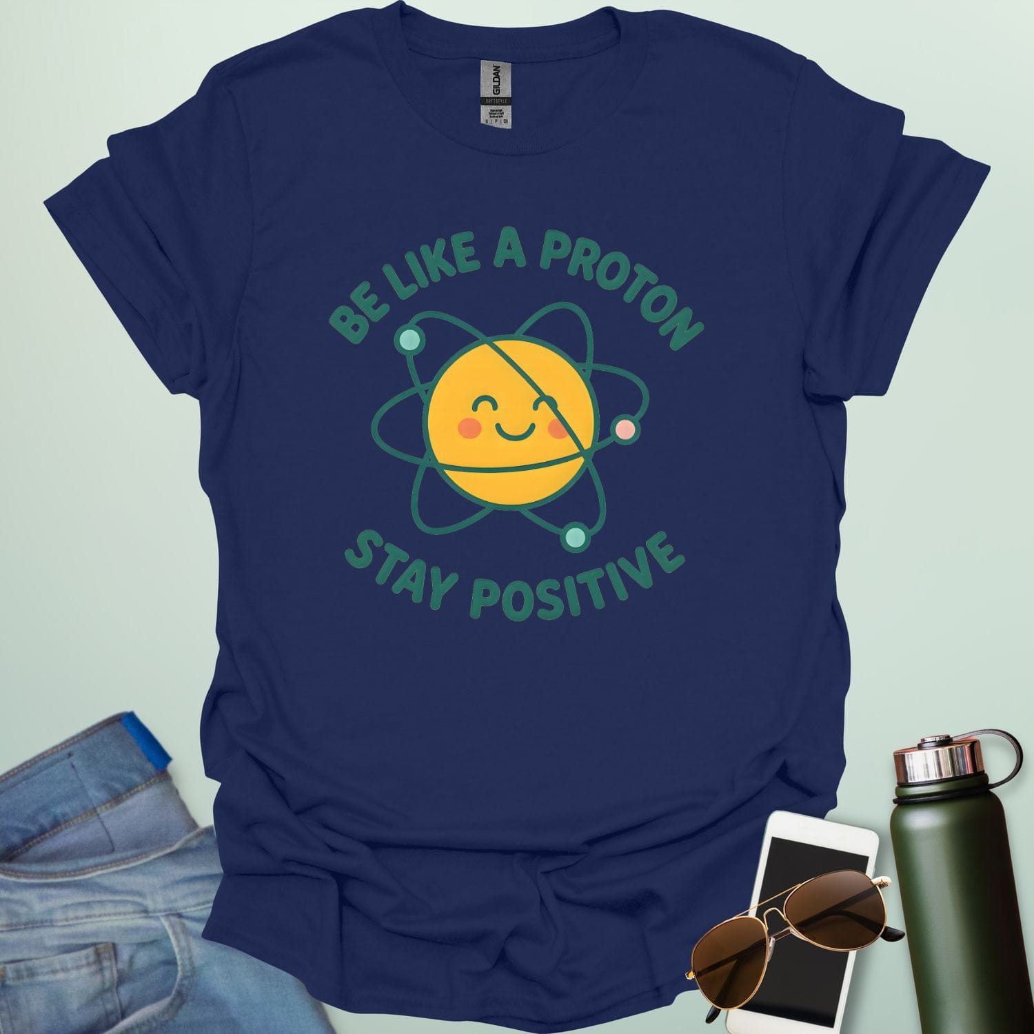 A cheerful graphic design featuring a smiling yellow proton character with orbiting electrons and the text "BE LIKE A PROTON STAY POSITIVE."
