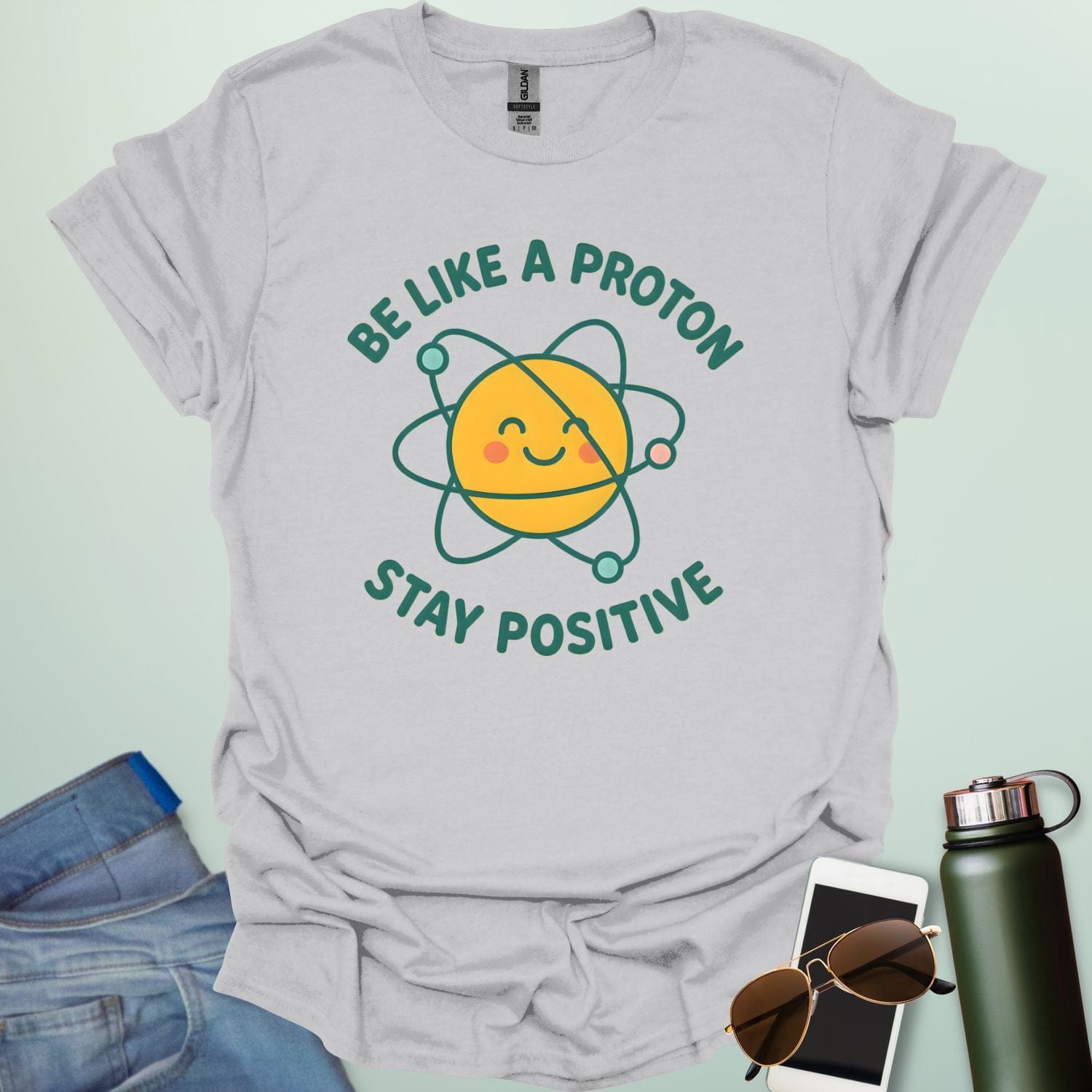 A cheerful graphic design featuring a smiling yellow proton character with orbiting electrons and the text "BE LIKE A PROTON STAY POSITIVE."