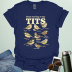 A t-shirt featuring the text "Stop staring at my TITS" above nine vintage-style illustrations of different tit bird species, including the Bearded, Crested, and Long Tailed tits.