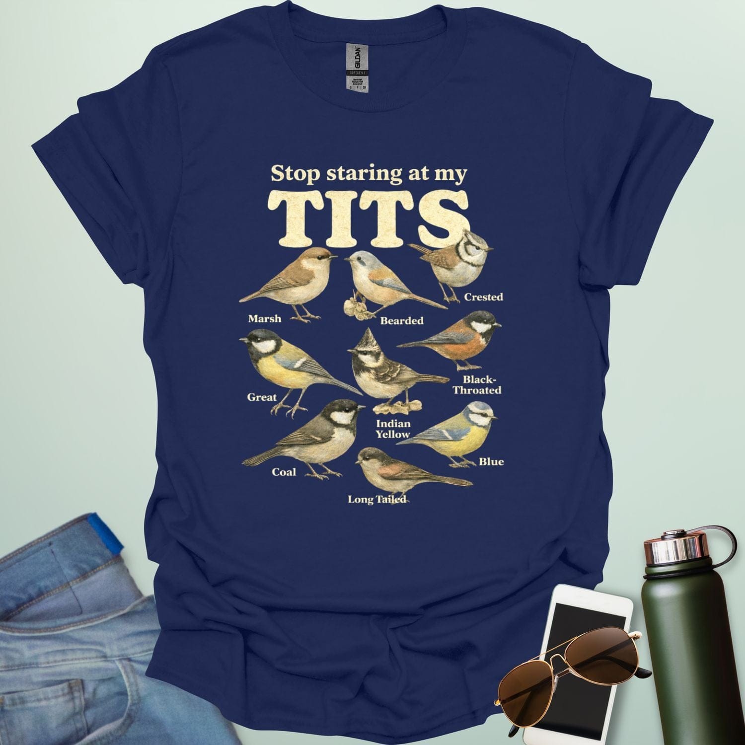 A t-shirt featuring the text "Stop staring at my TITS" above nine vintage-style illustrations of different tit bird species, including the Bearded, Crested, and Long Tailed tits.