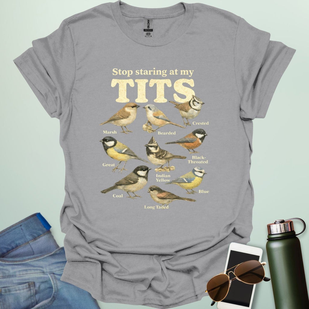 A t-shirt featuring the text "Stop staring at my TITS" above nine vintage-style illustrations of different tit bird species, including the Bearded, Crested, and Long Tailed tits.
