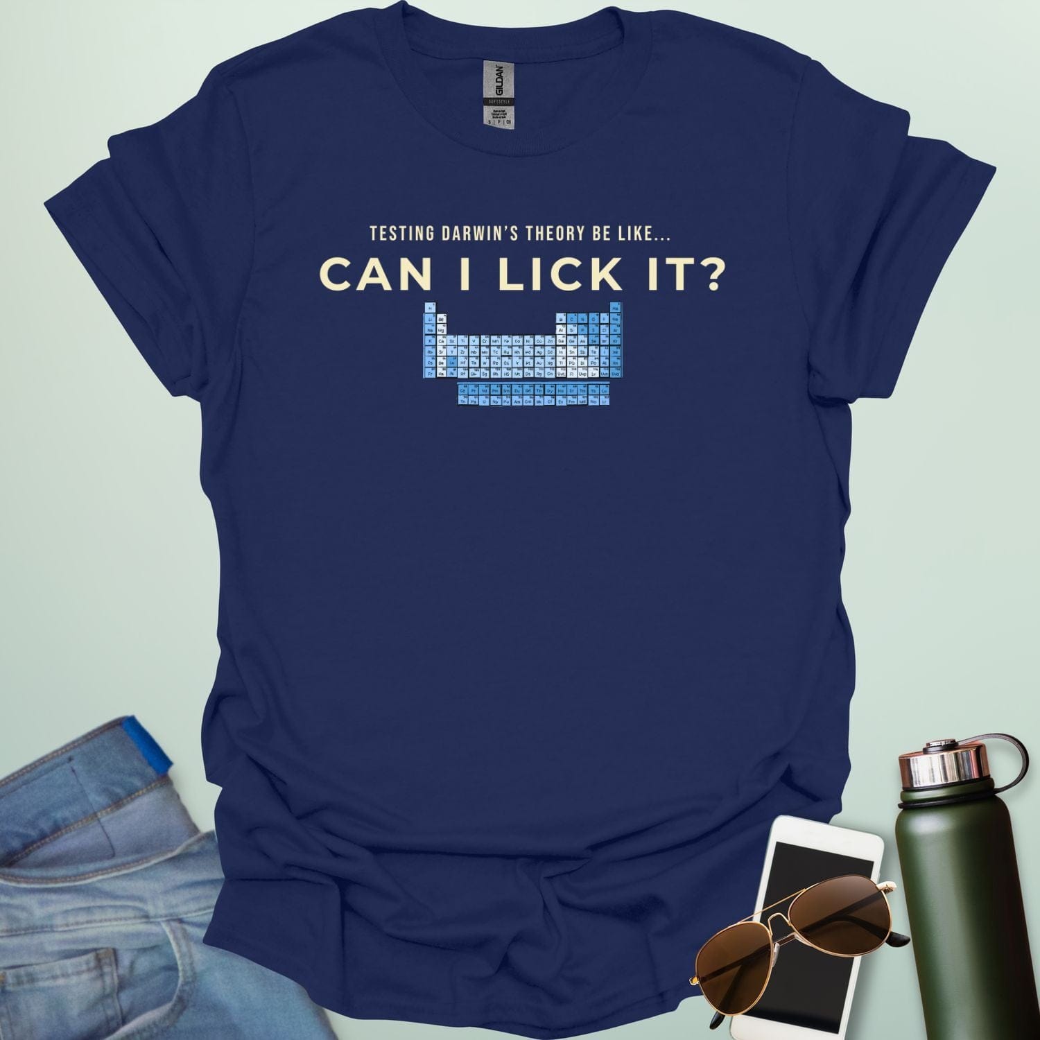 A graphic design featuring the text "TESTING DARWIN'S THEORY BE LIKE..." above the large question "CAN I LICK IT?" and a blue-toned periodic table of elements.