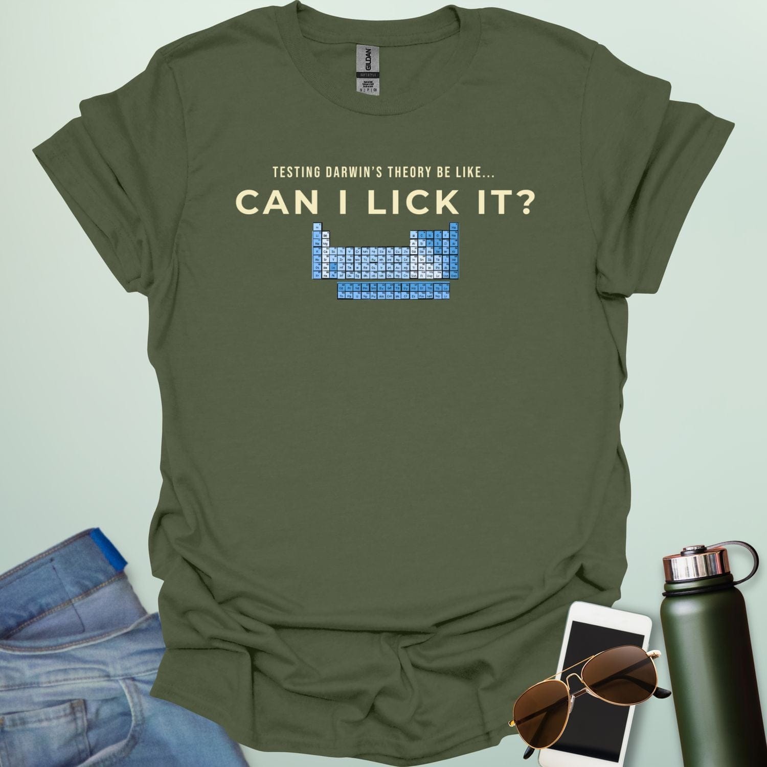 A graphic design featuring the text "TESTING DARWIN'S THEORY BE LIKE..." above the large question "CAN I LICK IT?" and a blue-toned periodic table of elements.