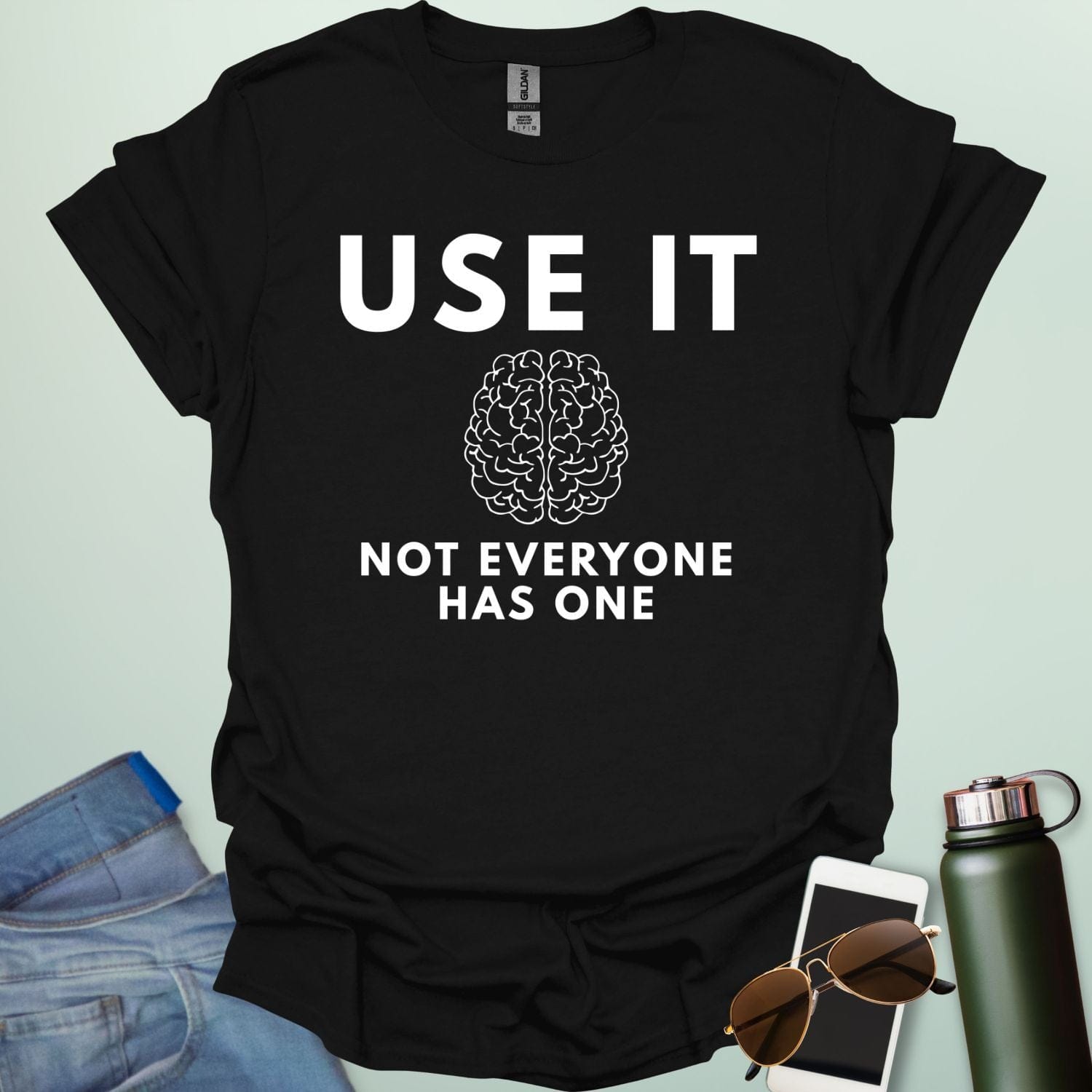 A minimalist graphic design featuring a detailed line-art illustration of a human brain centered between the bold text "USE IT" and "NOT EVERYONE HAS ONE."