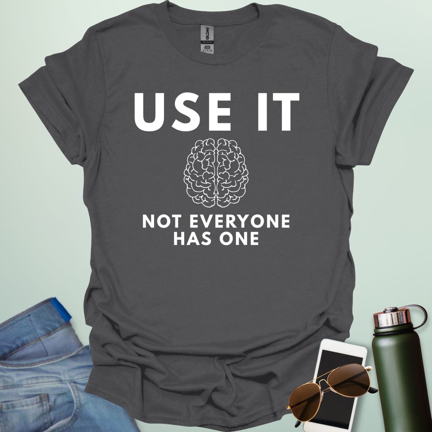 A minimalist graphic design featuring a detailed line-art illustration of a human brain centered between the bold text "USE IT" and "NOT EVERYONE HAS ONE."