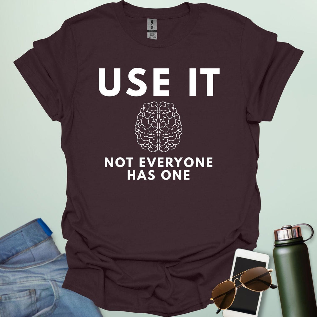 A minimalist graphic design featuring a detailed line-art illustration of a human brain centered between the bold text "USE IT" and "NOT EVERYONE HAS ONE."