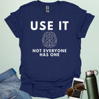 A minimalist graphic design featuring a detailed line-art illustration of a human brain centered between the bold text "USE IT" and "NOT EVERYONE HAS ONE."