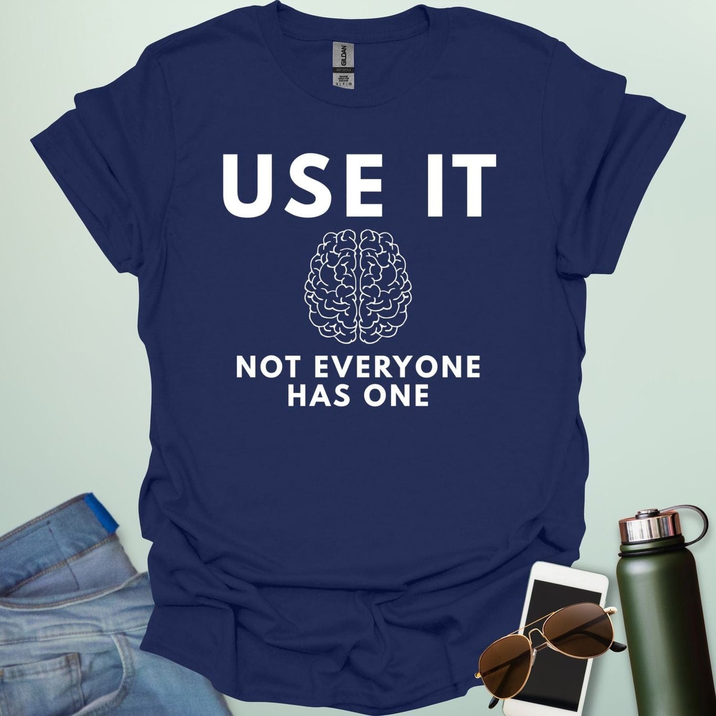 A minimalist graphic design featuring a detailed line-art illustration of a human brain centered between the bold text "USE IT" and "NOT EVERYONE HAS ONE."