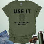 A minimalist graphic design featuring a detailed line-art illustration of a human brain centered between the bold text "USE IT" and "NOT EVERYONE HAS ONE."