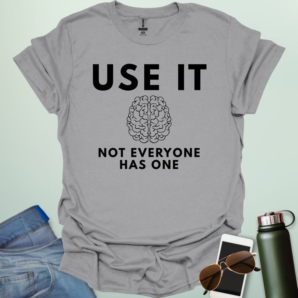 A minimalist graphic design featuring a detailed line-art illustration of a human brain centered between the bold text "USE IT" and "NOT EVERYONE HAS ONE."