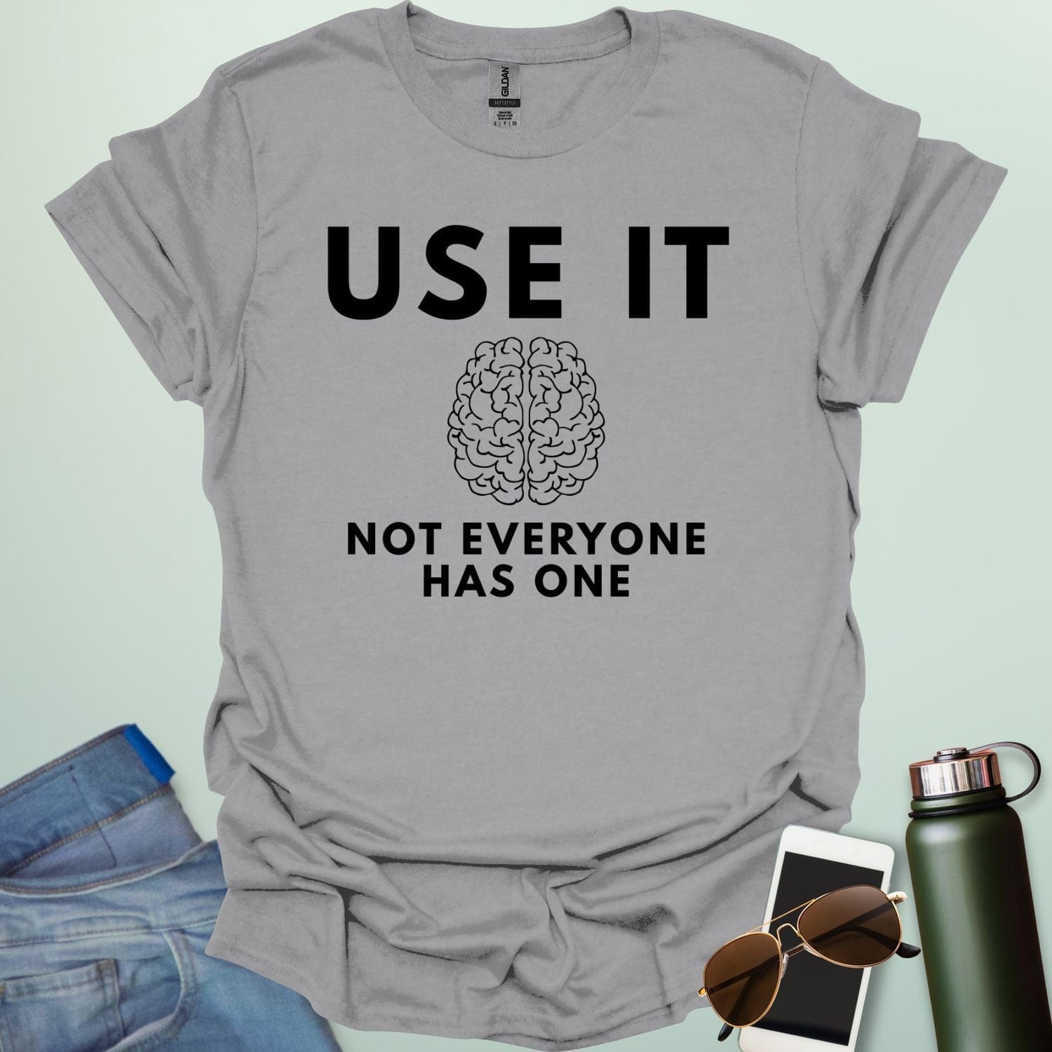A minimalist graphic design featuring a detailed line-art illustration of a human brain centered between the bold text "USE IT" and "NOT EVERYONE HAS ONE."
