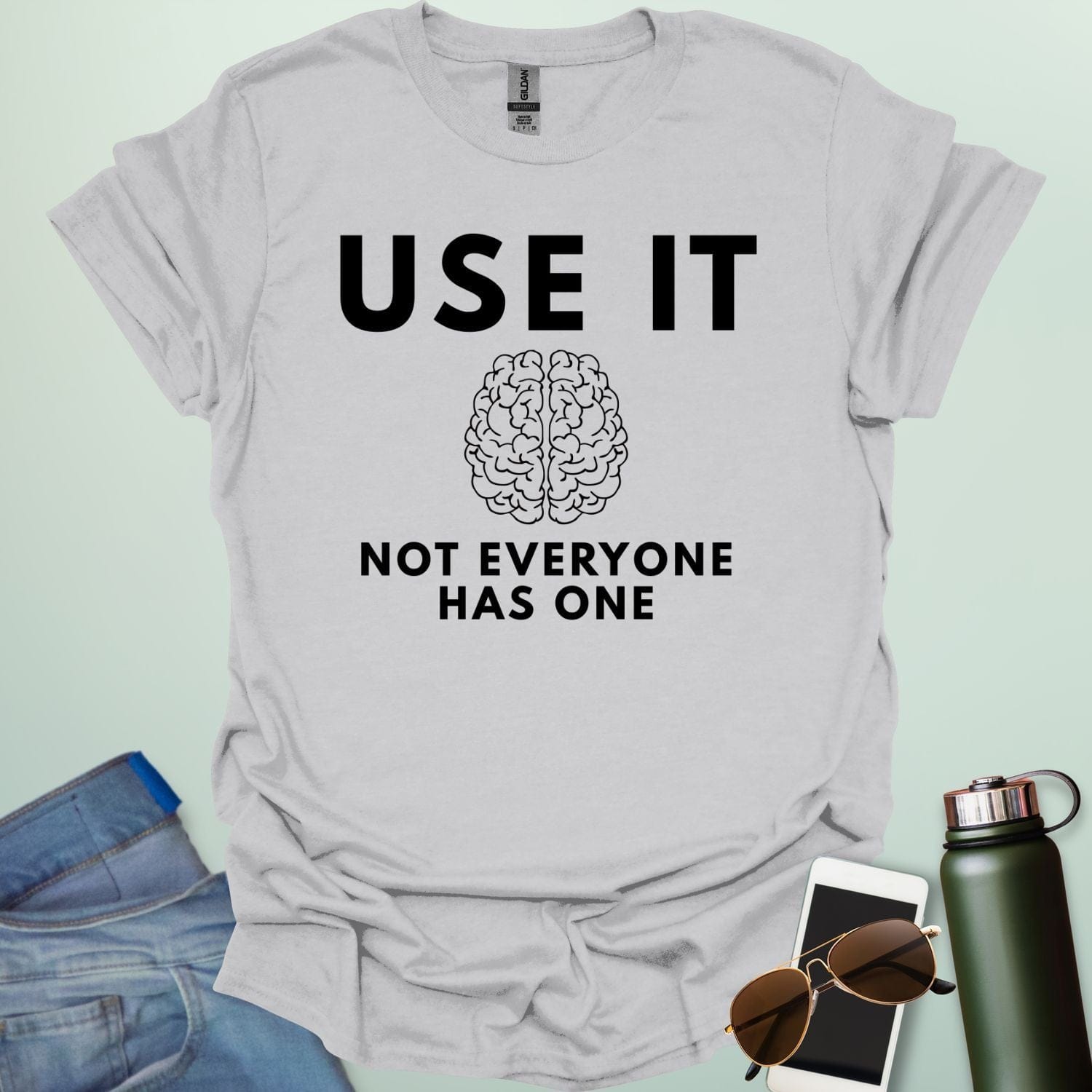A minimalist graphic design featuring a detailed line-art illustration of a human brain centered between the bold text "USE IT" and "NOT EVERYONE HAS ONE."