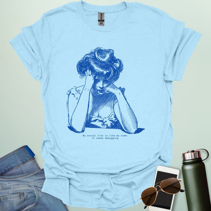 A light blue shirt with blue line art illustration of a woman looking frustrated with her head in her hands, above the text 'My social life is like my code:' and 'It needs debugging.
