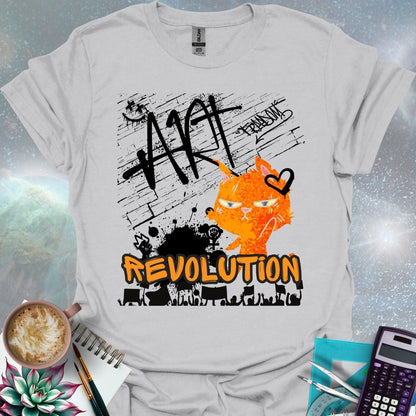 The word 'ART' in a bold, black graffiti style above an orange cartoon cat with a determined expression and a heart graphic. Below is the word 'REVOLUTION' in orange outlined in black, above a silhouette of a crowd holding signs.
