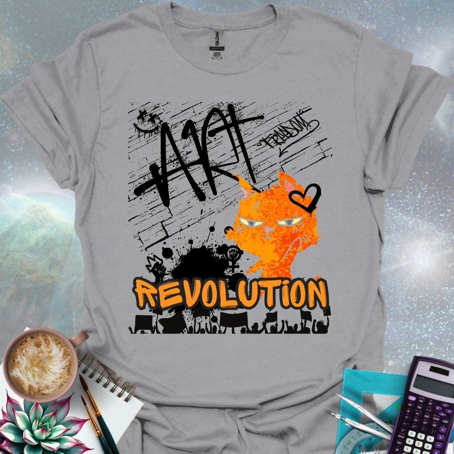 The word 'ART' in a bold, black graffiti style above an orange cartoon cat with a determined expression and a heart graphic. Below is the word 'REVOLUTION' in orange outlined in black, above a silhouette of a crowd holding signs.