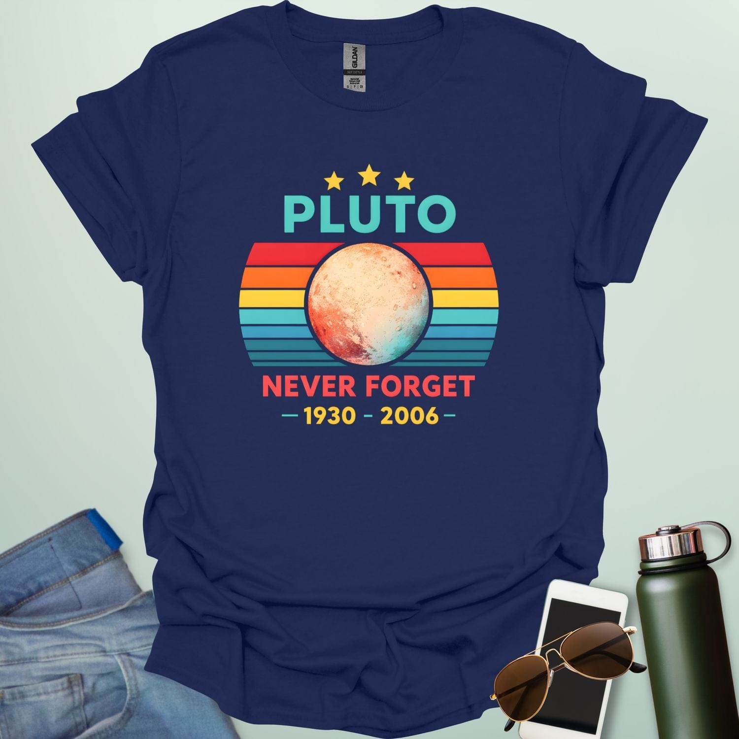A retro-style graphic featuring the planet Pluto in front of a striped sunset background with the text "PLUTO NEVER FORGET — 1930 - 2006 —".