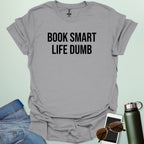 Minimalist typography design featuring the bold, all-caps text "BOOK SMART LIFE DUMB" centered in a clean sans-serif font.