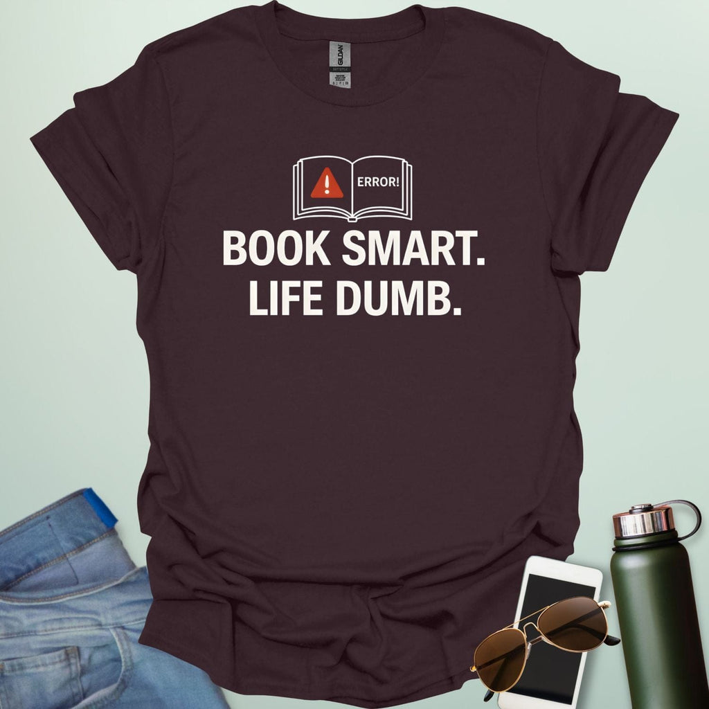 A minimalist graphic design featuring an open book with a red warning triangle and the word "ERROR!" above the bold text "BOOK SMART. LIFE DUMB."
