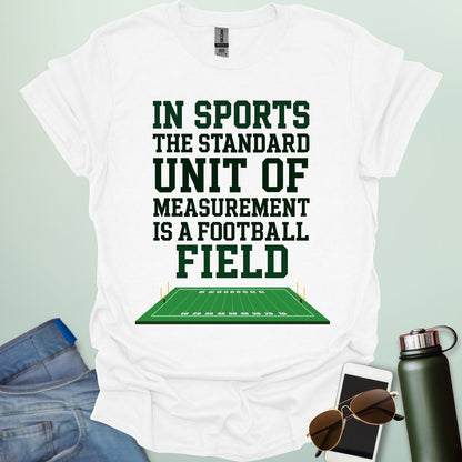 A white t-shirt with the text 'IN SPORTS THE STANDARD UNIT OF MEASUREMENT IS A FOOTBALL FIELD' above an illustration of a football field.