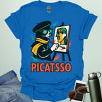 A royal blue t-shirt with a cartoon of a cat painting a Picasso-style portrait on an easel and the text 'PICATSSO' below.
