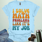 A t-shirt with the text 'I SOLVE MATH PROBLEMS LIKE IT'S MY JOB' printed in a retro, colorful, and bold font.