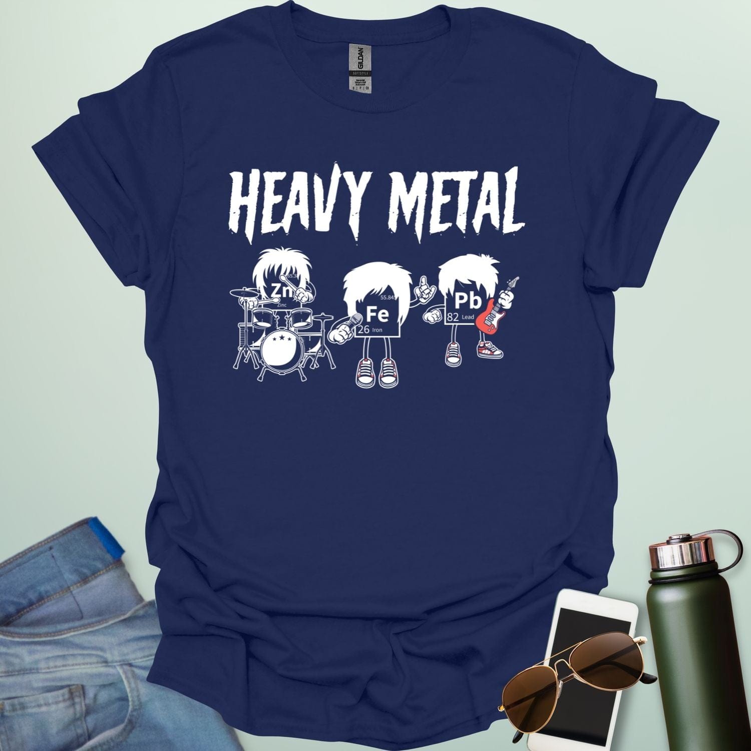 A navy blue t-shirt with a cartoon graphic of three chemical elements—Zn, Fe, and Pb—dressed as a heavy metal rock band with the text 'HEAVY METAL' above them.