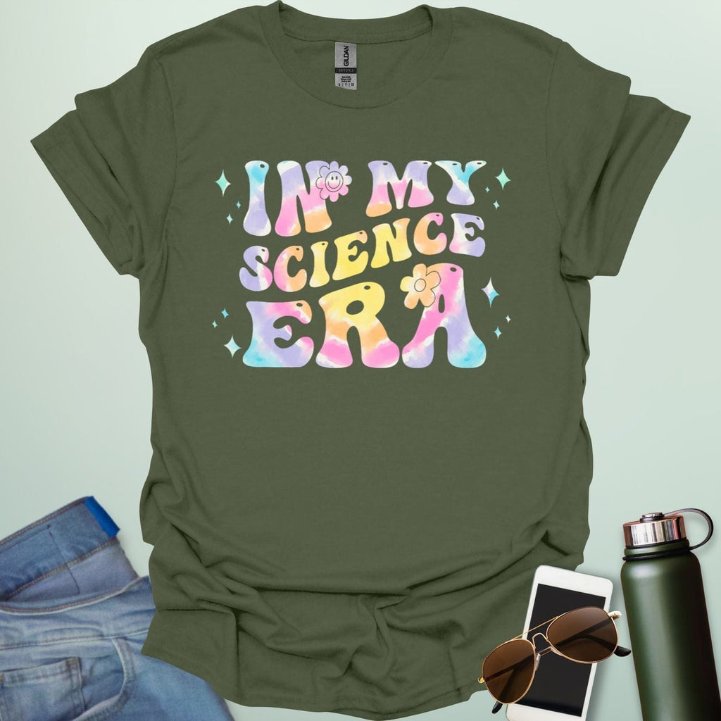 A military green t-shirt with wavy, tie-dye text that says 'IN MY SCIENCE ERA' with flowers and stars.