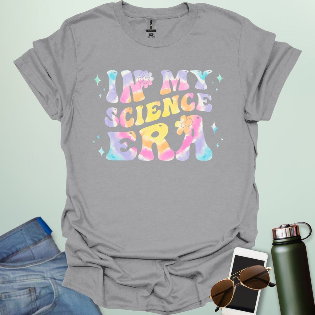 A sport grey t-shirt with wavy, tie-dye text that says 'IN MY SCIENCE ERA' with flowers and stars.