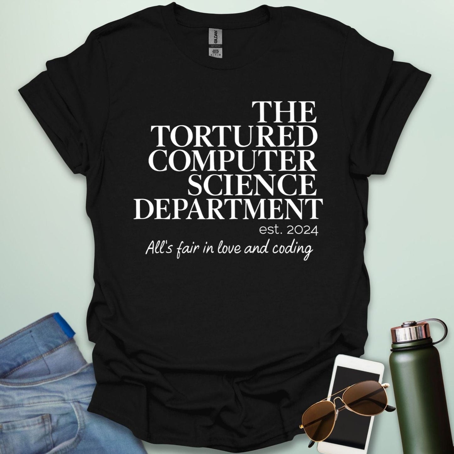 A black t-shirt with the text 'THE TORTURED COMPUTER SCIENCE DEPARTMENT est. 2024' and 'All's fair in love and coding.'