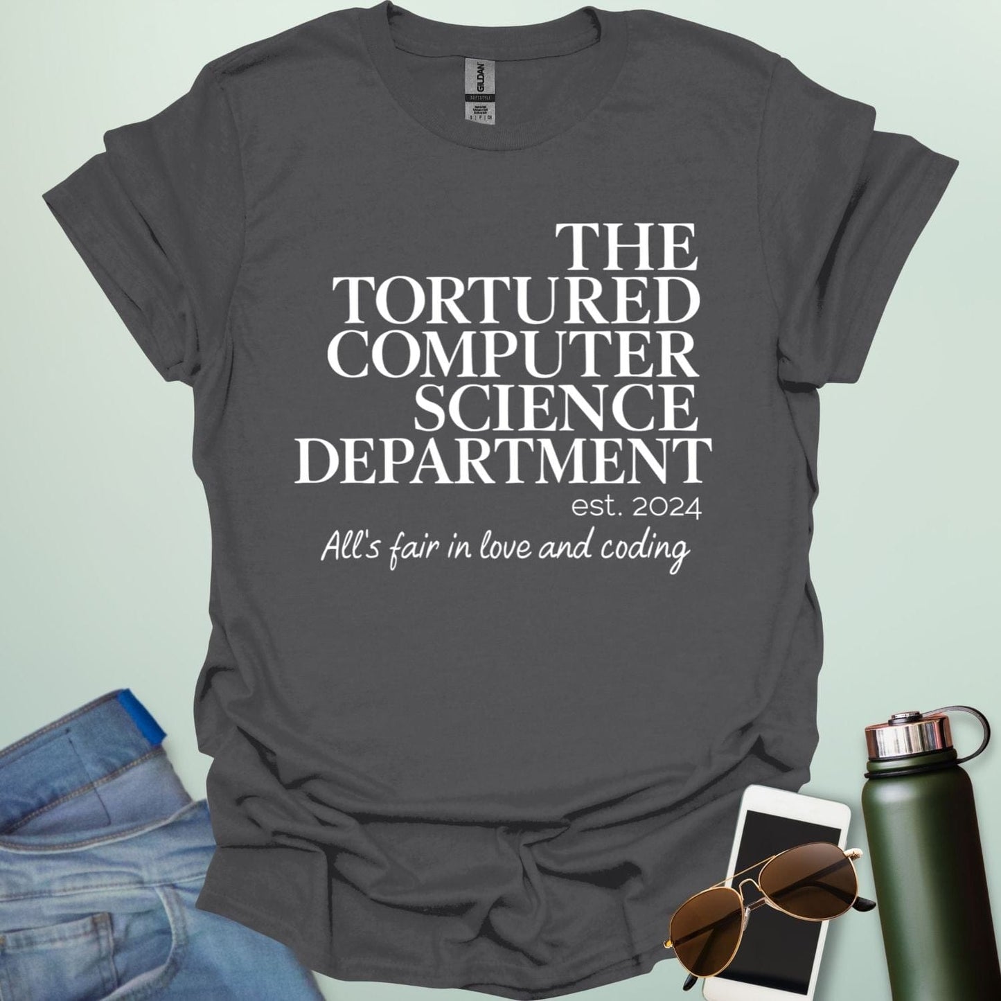 A charcoal grey t-shirt with the text 'THE TORTURED COMPUTER SCIENCE DEPARTMENT est. 2024' and 'All's fair in love and coding.'