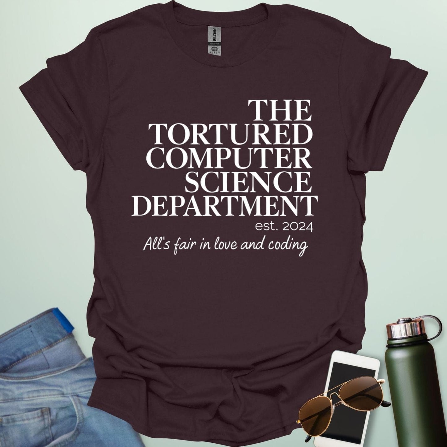 A dark chocolate t-shirt with the text 'THE TORTURED COMPUTER SCIENCE DEPARTMENT est. 2024' and 'All's fair in love and coding.'