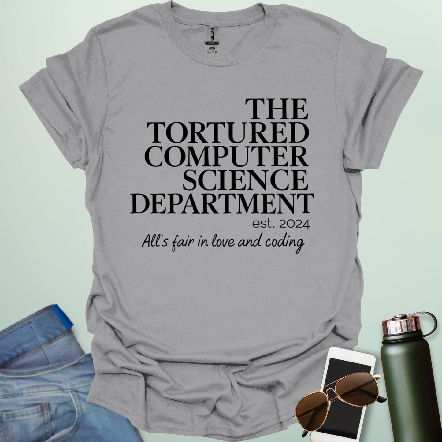 A sport grey t-shirt with the text 'THE TORTURED COMPUTER SCIENCE DEPARTMENT est. 2024' and 'All's fair in love and coding.'