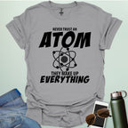 'Never Trust an Atom, They Make Up Everything' funny science t-shirt with atom graphic.