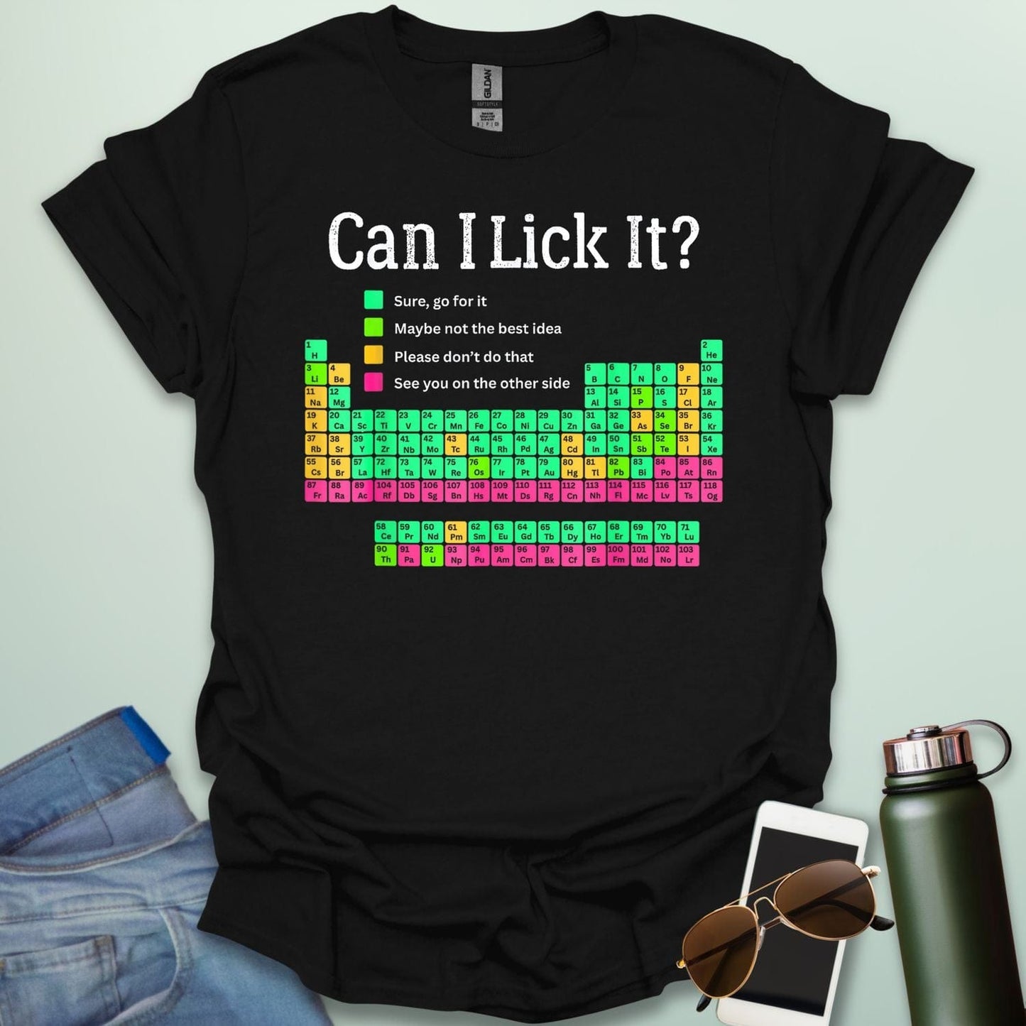 Can I Lick It?' periodic table t-shirt with a color-coded chart of elements and a funny chemistry warning.