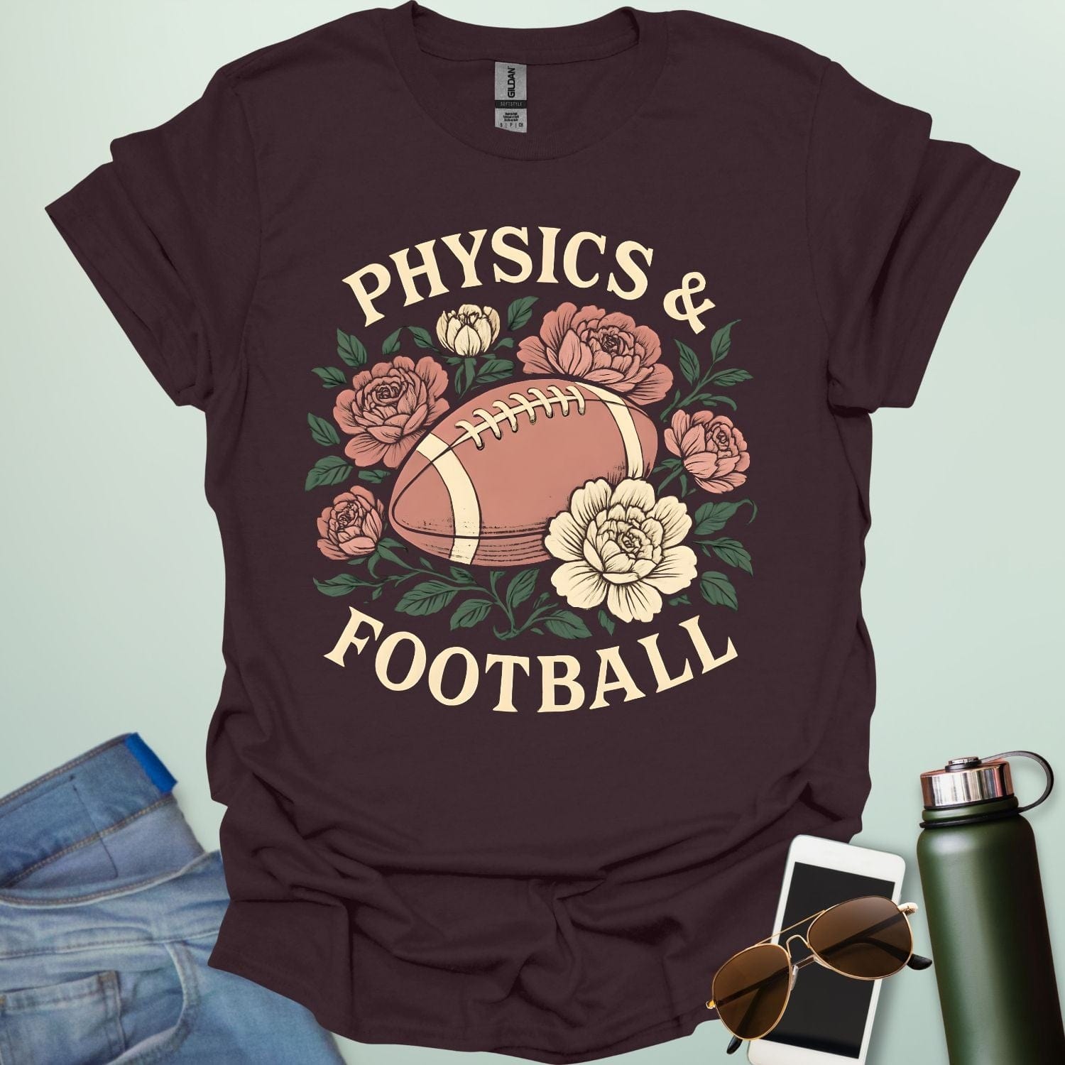 A dark chocolate t-shirt with a vintage illustration of a football surrounded by flowers and the text 'PHYSICS & FOOTBALL.'